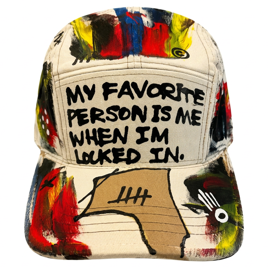 A structured baseball cap with a cream-colored front panel featuring the text 'MY FAVORITE PERSON IS ME WHEN I'M LOOKED IN.' in black handwritten-style lettering.